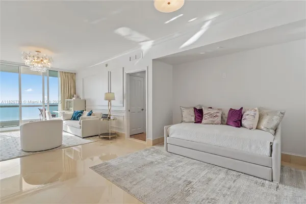 a living room with furniture and a chandelier