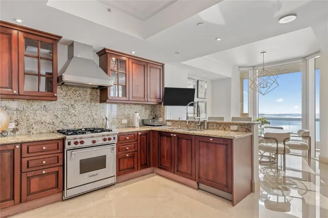 a kitchen with stainless steel appliances granite countertop a stove sink and cabinets