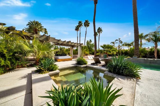 a living room with large windows and a chandelier