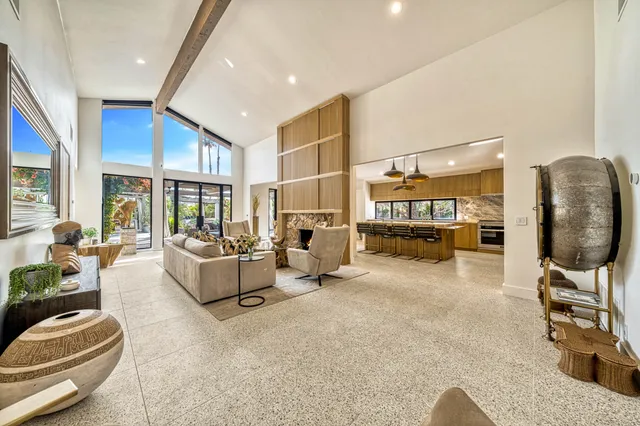 a living room with furniture fireplace and a large window