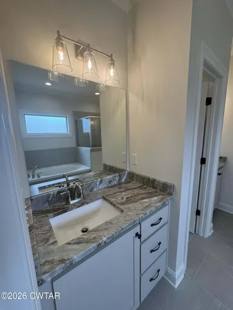 a bathroom with a granite countertop sink and a mirror