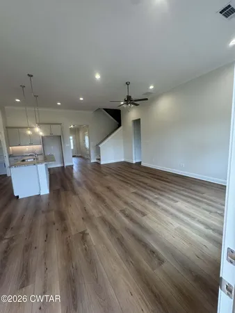 a view of a kitchen with a sink and wooden floor