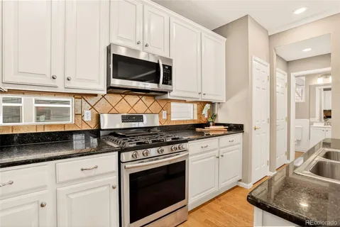 a kitchen with stainless steel appliances granite countertop a stove a sink and a microwave