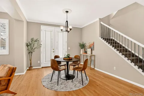 a dining room with furniture a chandelier and wooden floor