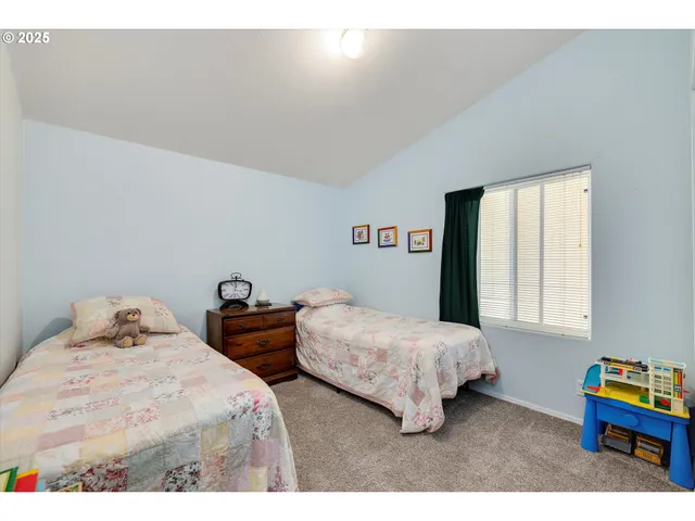 a bedroom with two beds and a chair