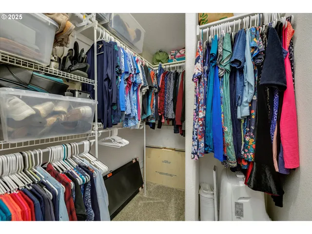 a view of walk in closet with clothes