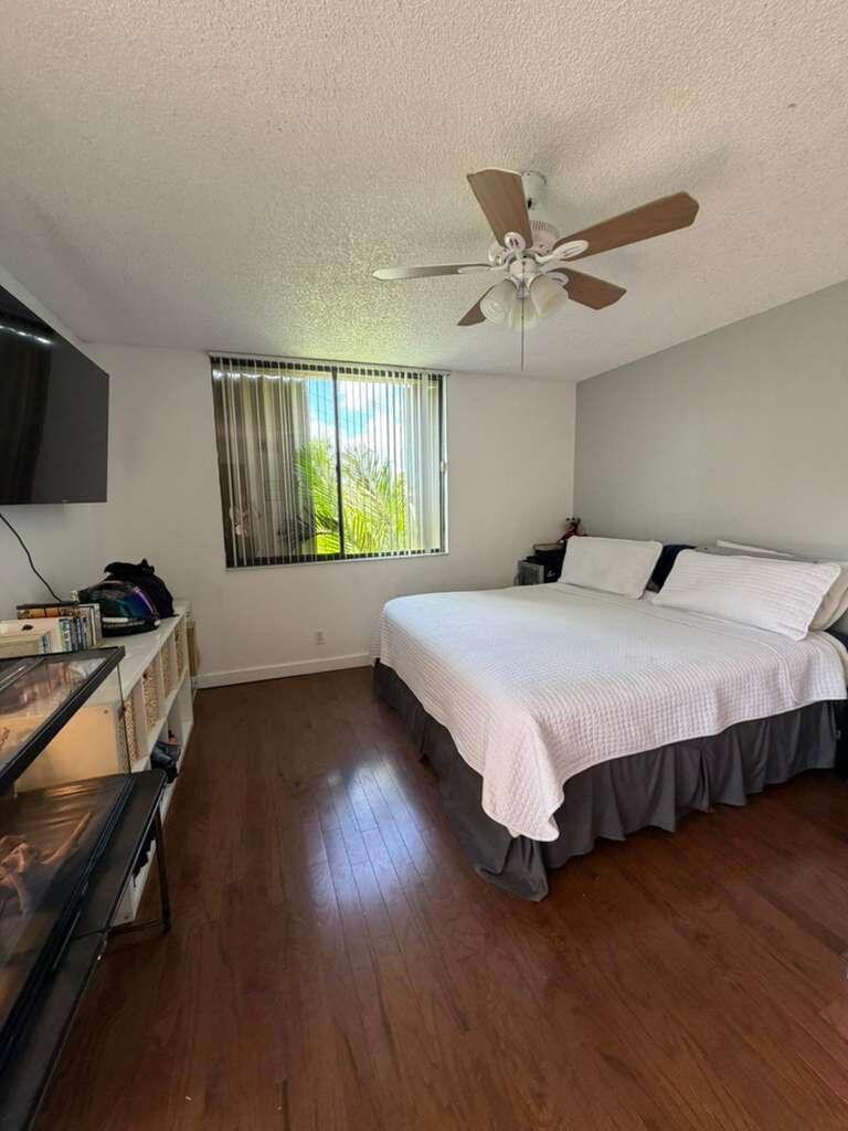 8182 Thames Boulevard, Unit D Boca Raton, FL 33433 - Photo 12 of 20 a bedroom with a bed and wooden floor