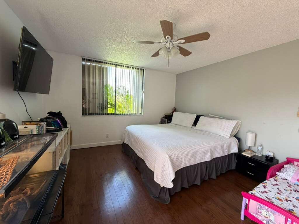 8182 Thames Boulevard, Unit D Boca Raton, FL 33433 - Photo 17 of 20 a bedroom with a bed and a flat screen tv