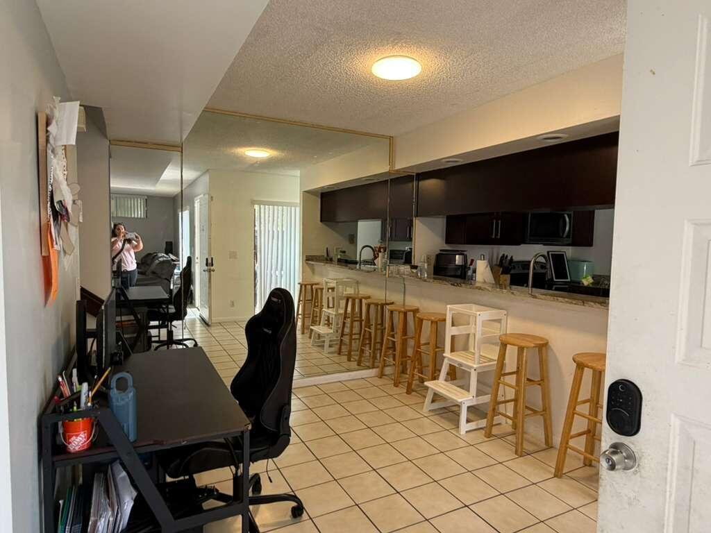 8182 Thames Boulevard, Unit D Boca Raton, FL 33433 - Photo 4 of 20 a kitchen with stainless steel appliances kitchen island granite countertop a stove a sink a dining table and chairs