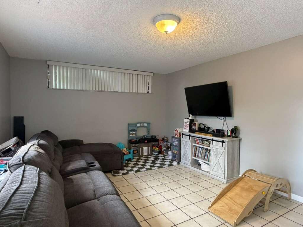 8182 Thames Boulevard, Unit D Boca Raton, FL 33433 - Photo 6 of 20 a bedroom with furniture and a flat screen tv