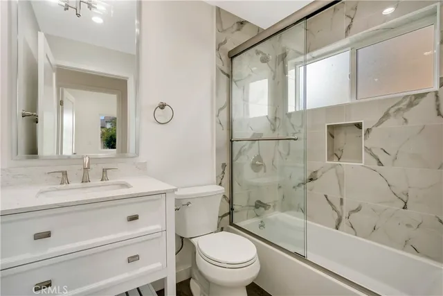 a bathroom with a bathtub toilet sink vanity and mirror