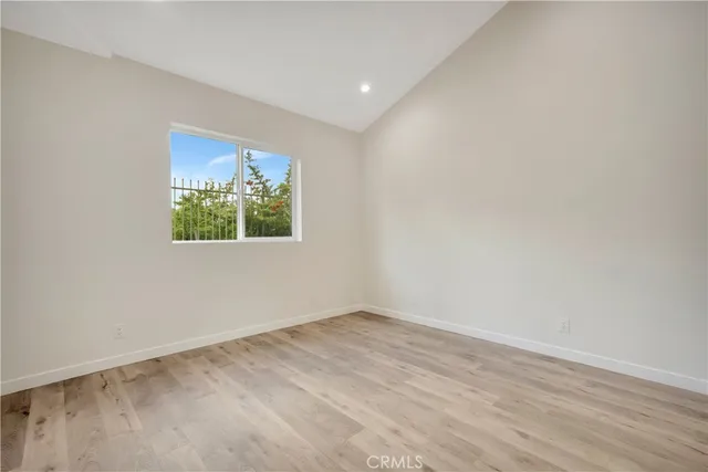 an empty room with wooden floor and window