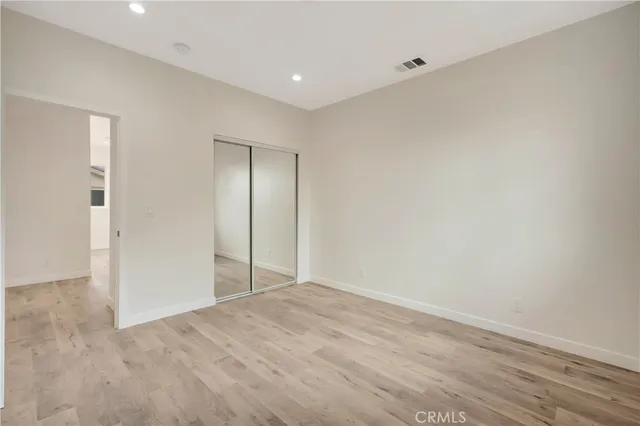 a spacious bedroom with a large bed and a chandelier