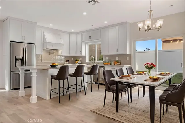 a view of kitchen with refrigerator dining table and chairs