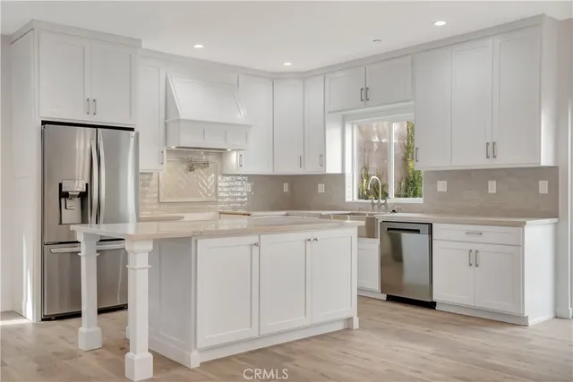 a kitchen with granite countertop white cabinets and stainless steel appliances