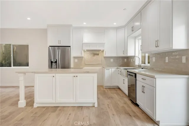 a kitchen with white cabinets and sink