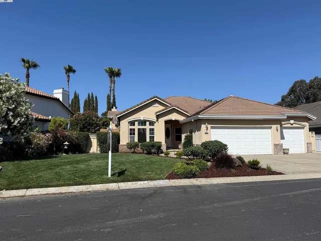 a front view of a house with a yard and potted plants