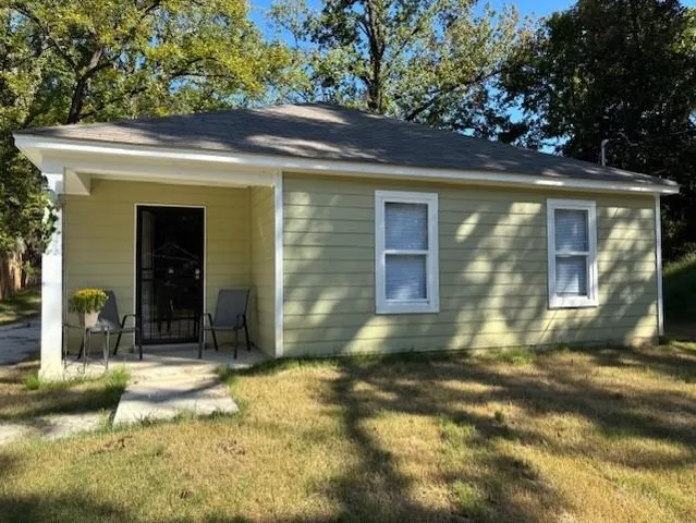 a view of brick house with a yard