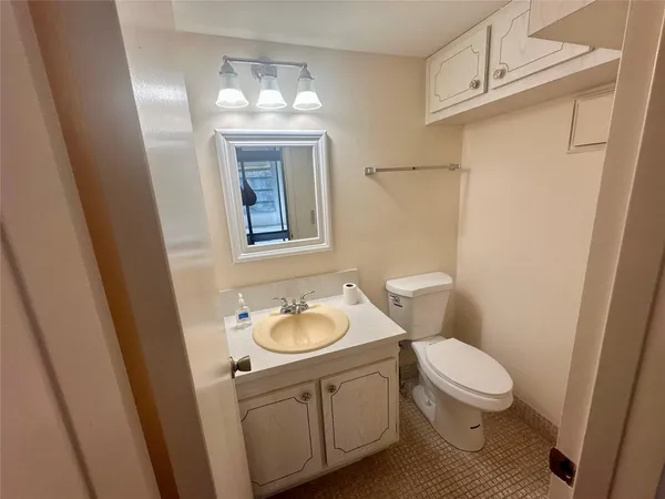 a bathroom with a granite countertop toilet sink and mirror