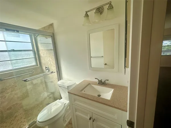 a bathroom with a sink a toilet and shower