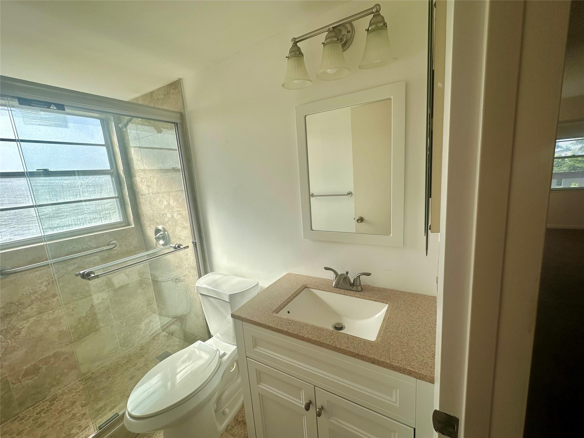 29 Preston A Boca Raton, FL 33434 - Photo 17 of 21 a bathroom with a sink a toilet and shower