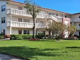a front view of a building with a garden