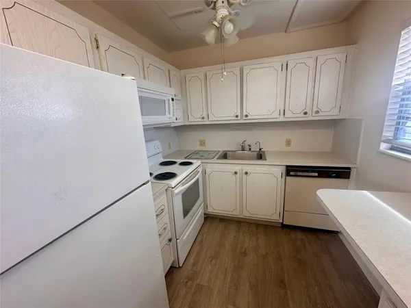 a kitchen with a white cabinets and white appliances
