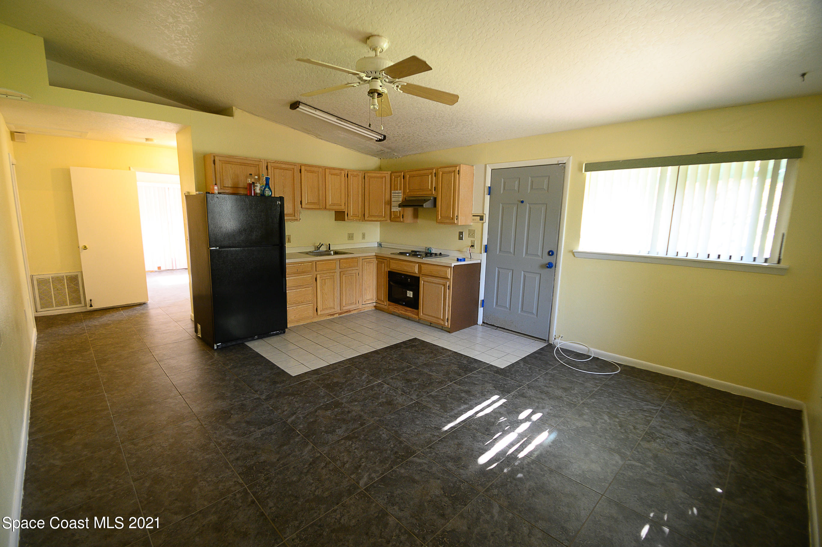 1003 Bernice Road Rockledge, FL 32955 - Photo 23 of 43 a kitchen with refrigerator and window