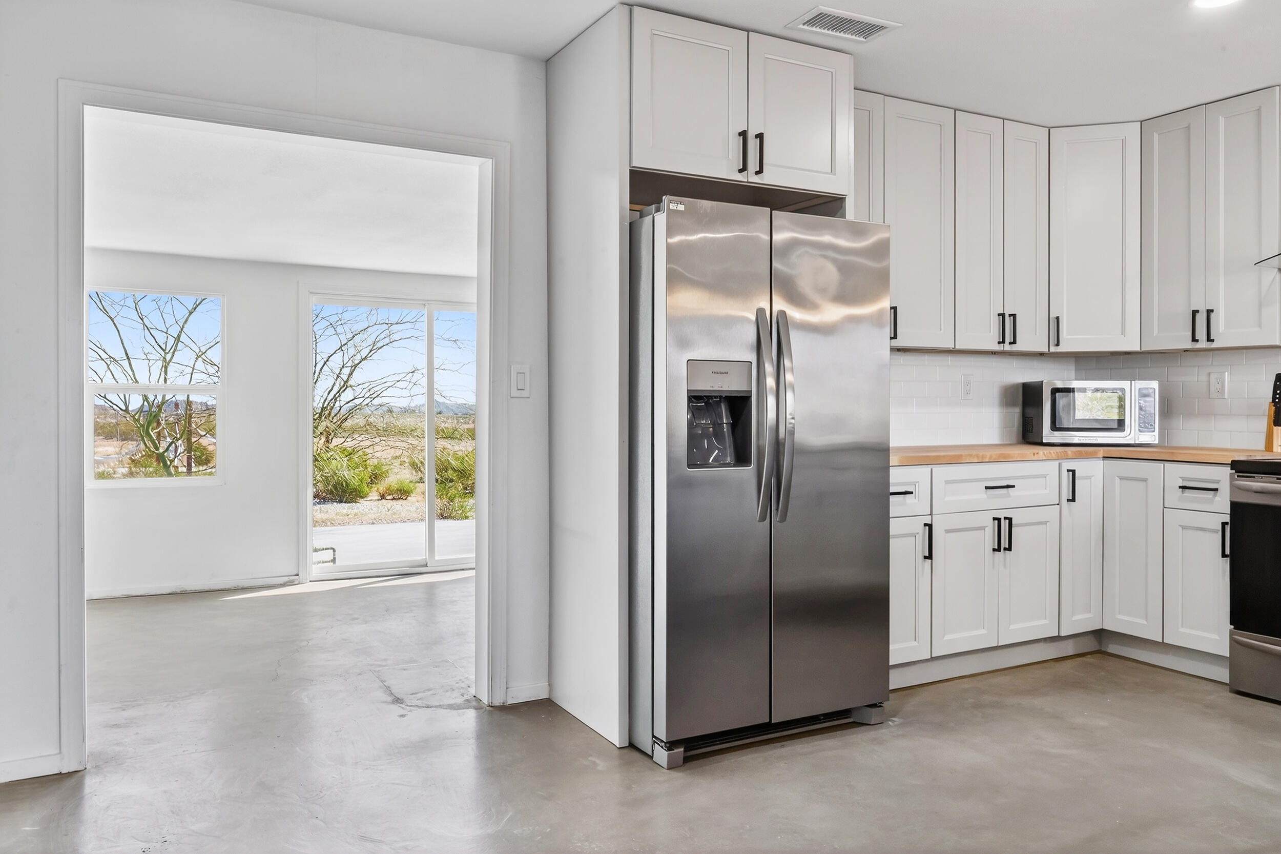 2071 Border Avenue Joshua Tree, CA 92252 - Photo 19 of 50 a kitchen with stainless steel appliances granite countertop a refrigerator a stove and a microwave