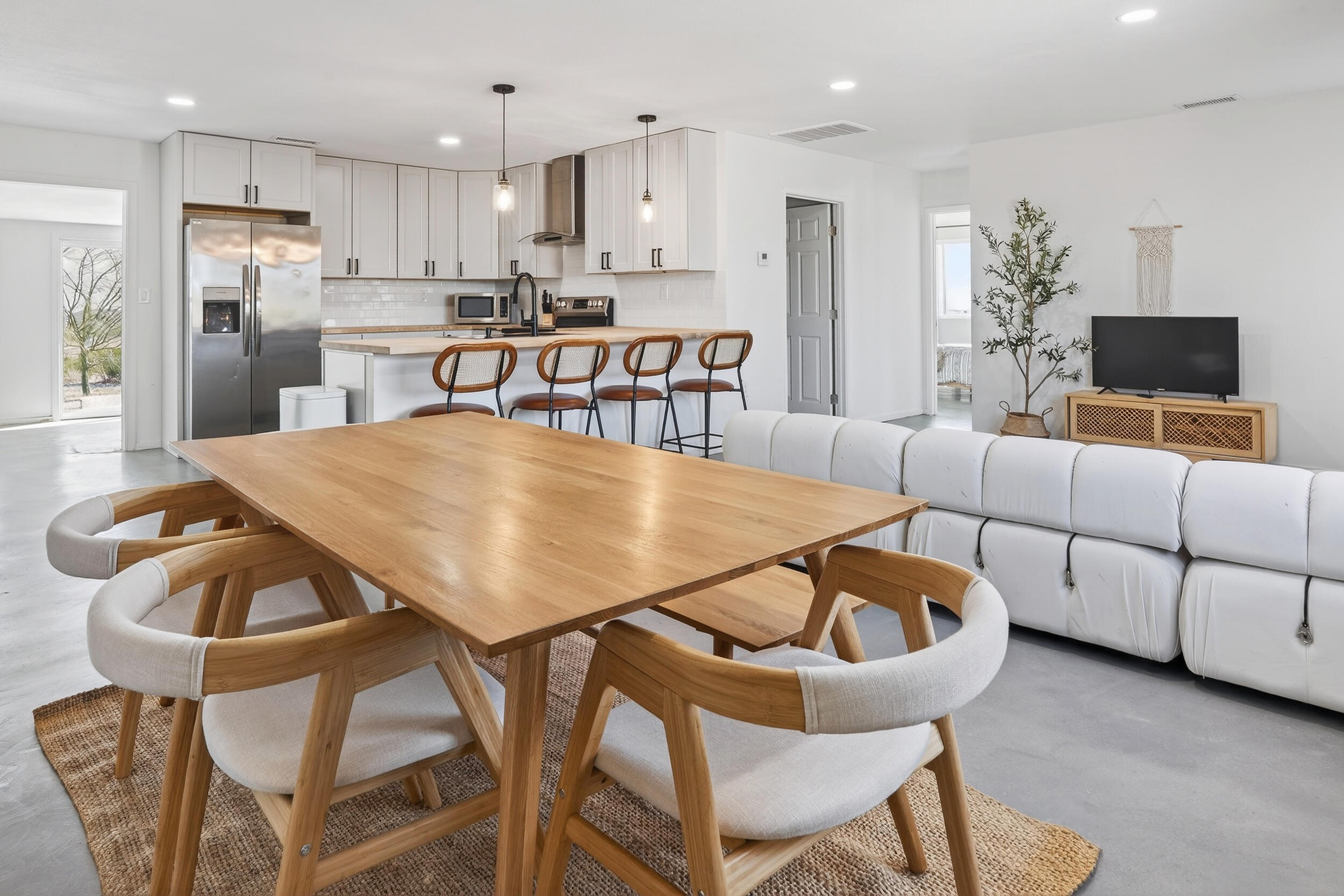 2071 Border Avenue Joshua Tree, CA 92252 - Photo 10 of 50 a living room with stainless steel appliances kitchen island granite countertop a dining table chairs and a kitchen view