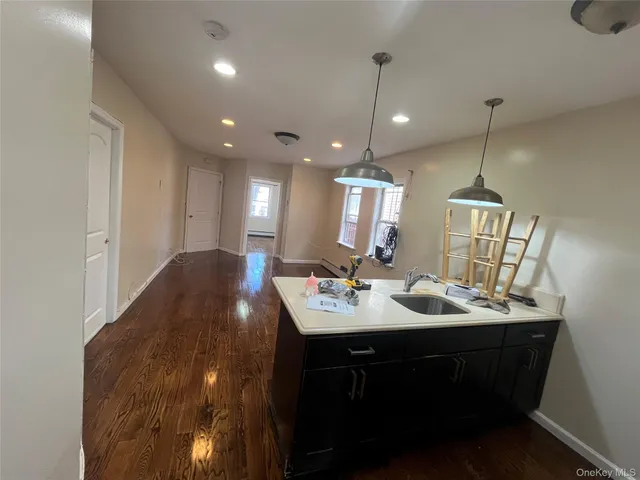 a kitchen with kitchen island granite countertop a sink stainless steel appliances and chairs