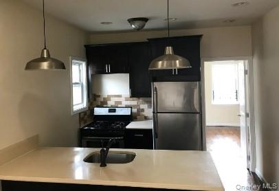 168-28 106th Avenue, Unit 1 Queens, NY 11433 - Photo 3 of 13 a kitchen with a refrigerator a sink and cabinets
