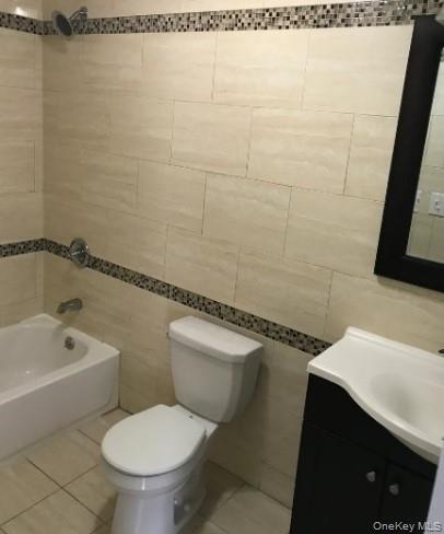168-28 106th Avenue, Unit 1 Queens, NY 11433 - Photo 4 of 13 a white toilet sitting next to a bath tub and a sink