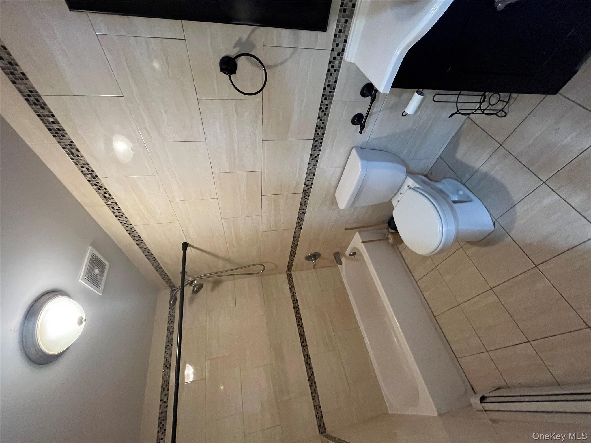 168-28 106th Avenue, Unit 1 Queens, NY 11433 - Photo 9 of 13 a bathroom with a sink a toilet and a shower