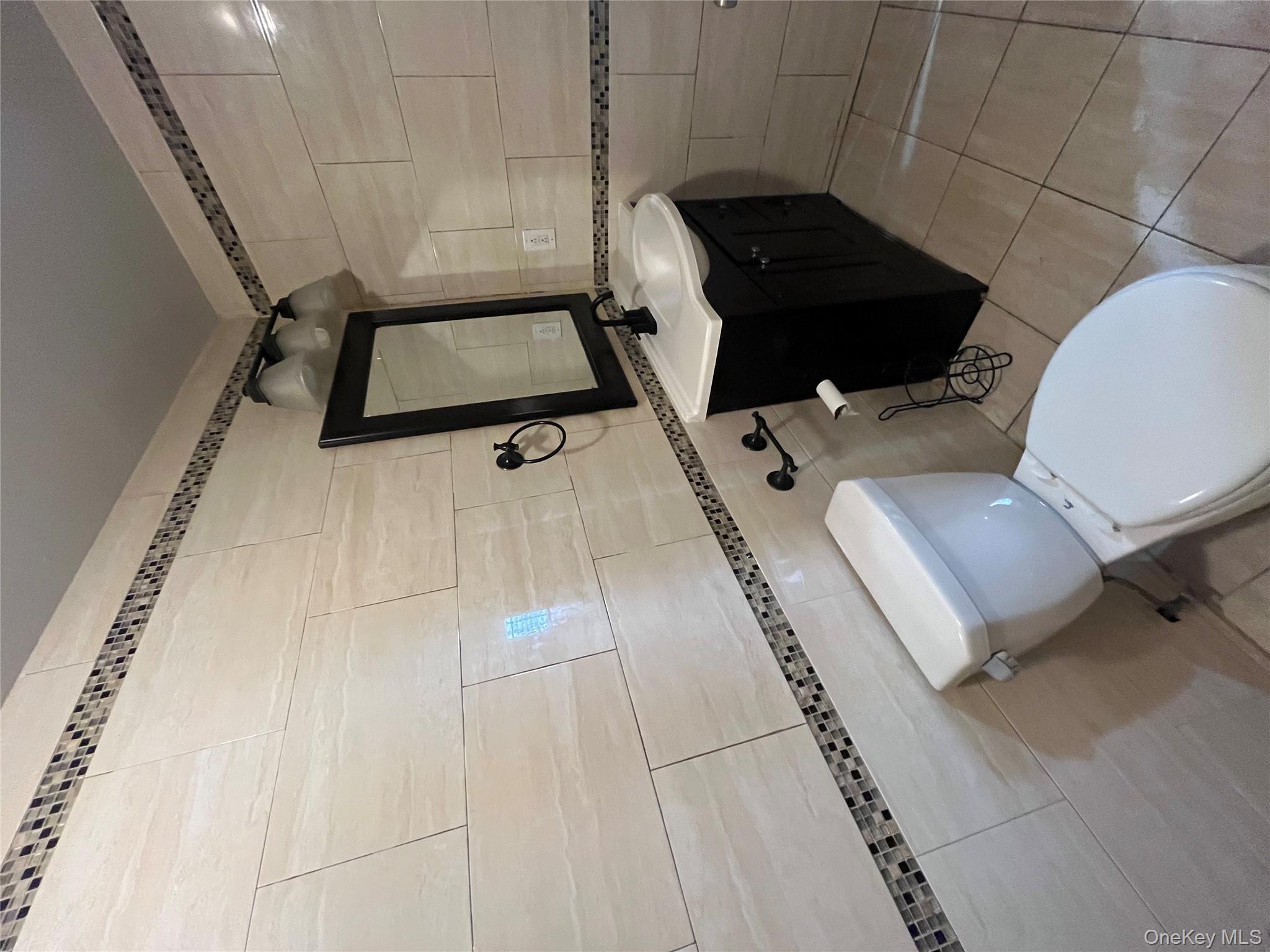 168-28 106th Avenue, Unit 1 Queens, NY 11433 - Photo 10 of 13 a bathroom with a toilet sink and mirror