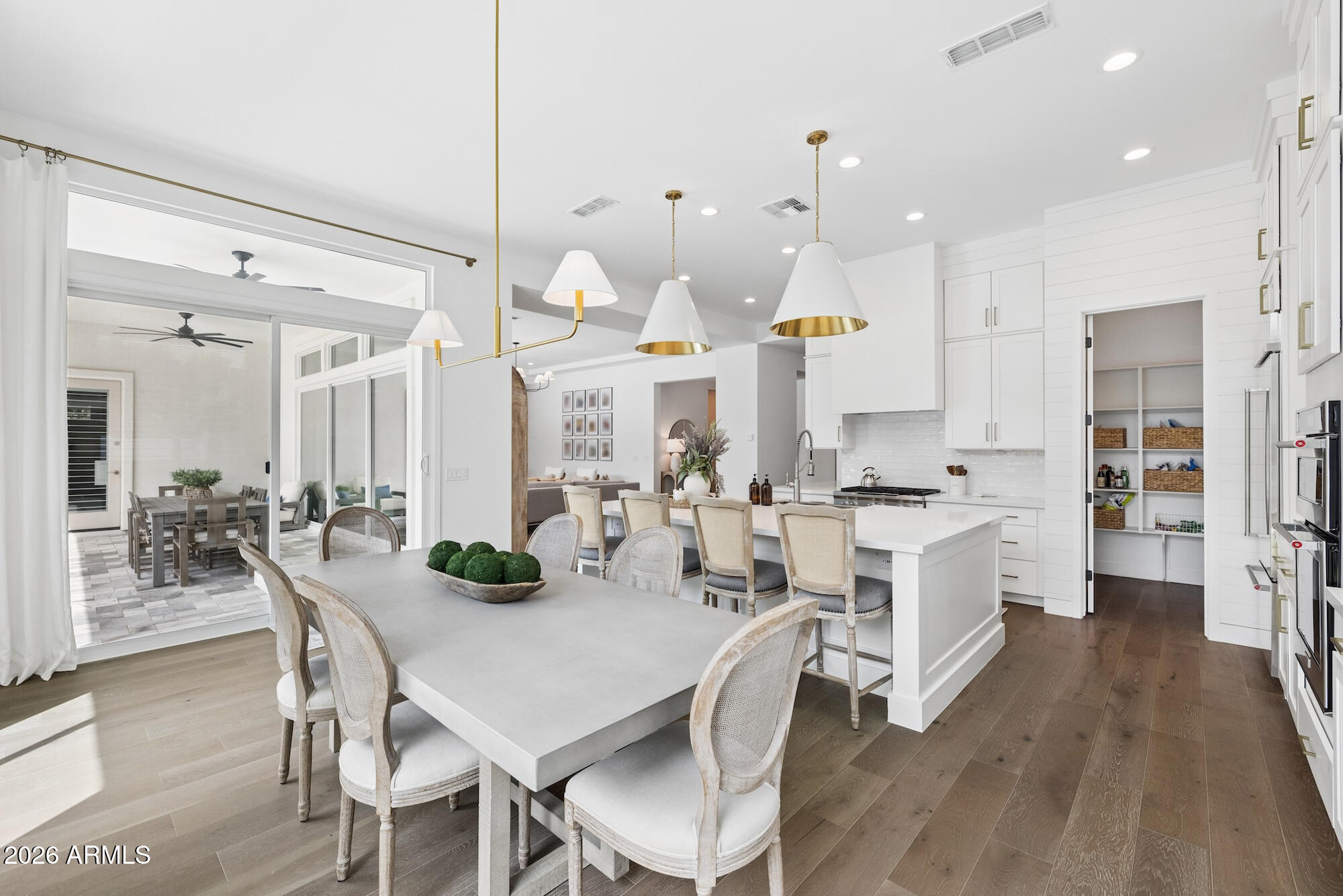2633 East Geronimo Street Gilbert, AZ 85295 - Photo 16 of 75 a kitchen with stainless steel appliances kitchen island granite countertop a table chairs and a refrigerator