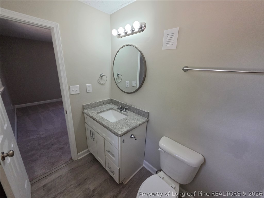 220 Cecil Avenue Spring Lake, NC 28390 - Photo 14 of 21 a bathroom with a toilet a sink and a mirror