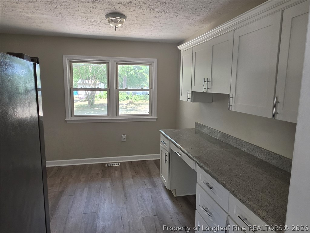 220 Cecil Avenue Spring Lake, NC 28390 - Photo 7 of 21 an empty room with wooden floor and window
