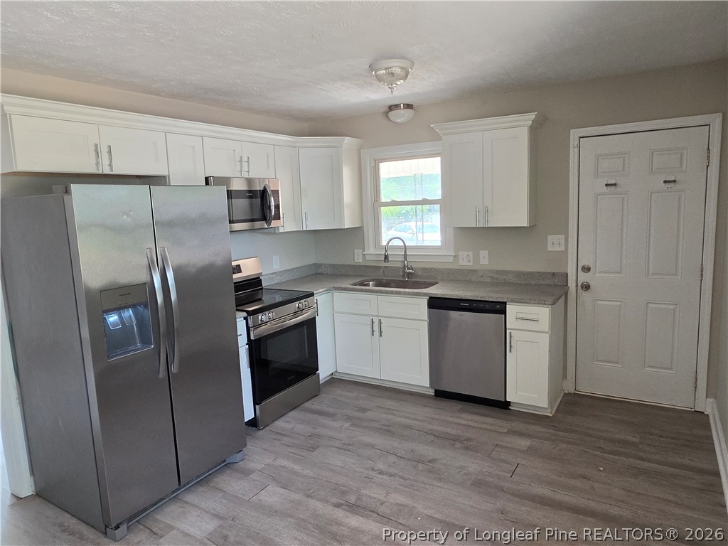 220 Cecil Avenue Spring Lake, NC 28390 - Photo 8 of 21 a kitchen with stainless steel appliances granite countertop a refrigerator sink and cabinets