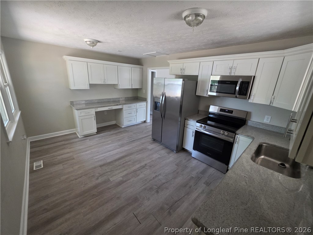 220 Cecil Avenue Spring Lake, NC 28390 - Photo 9 of 21 a kitchen with a refrigerator stove and microwave