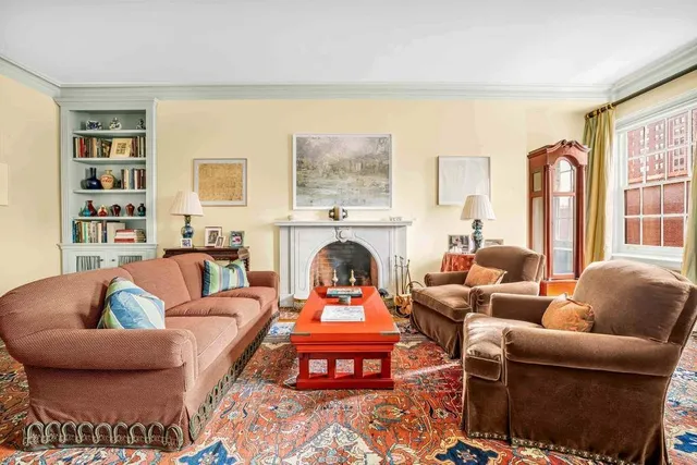 a living room with furniture fireplace and a large window