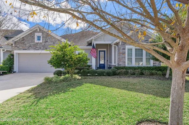 a front view of a house with a yard and potted plants