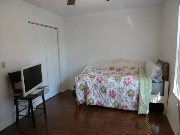a bedroom with a bed and wooden floor