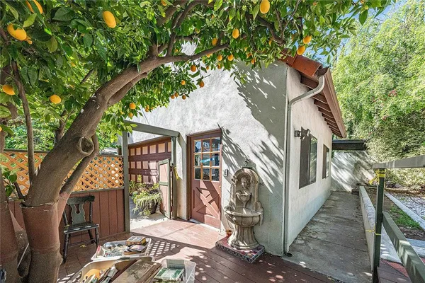 a view of a house with a small yard and large tree