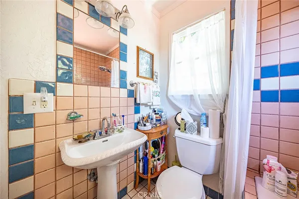 a bathroom with a sink a toilet a mirror and shower