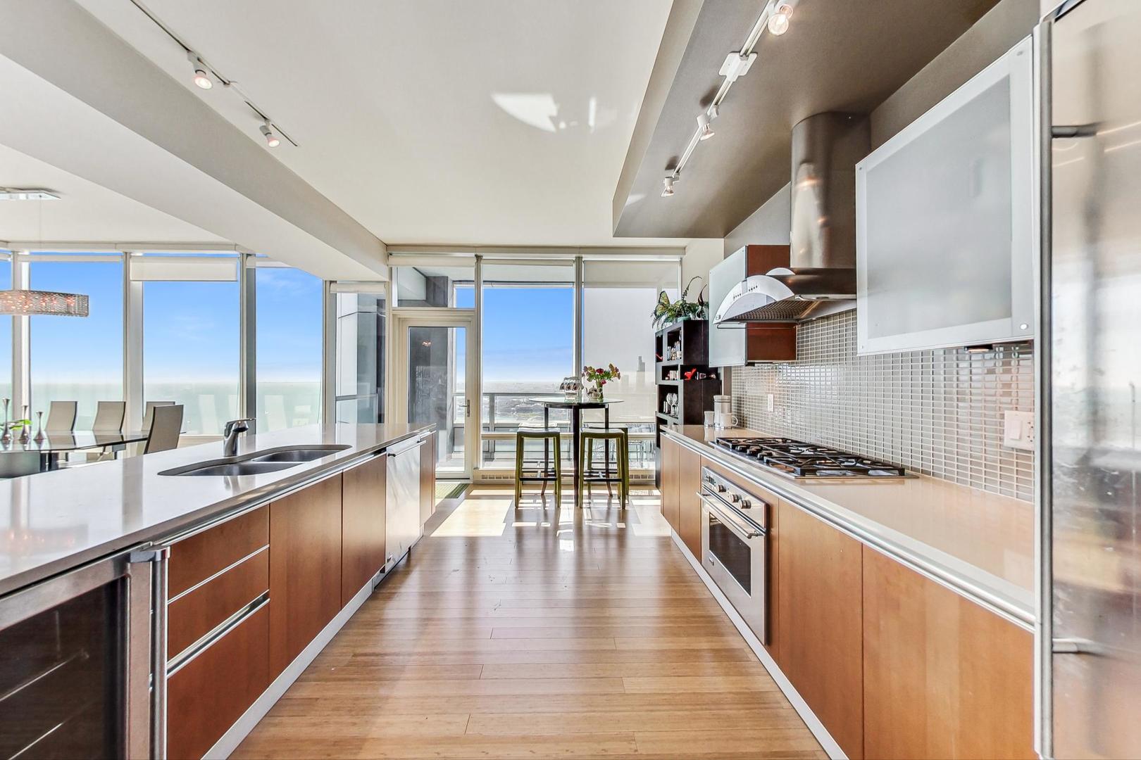 340 East Randolph Street, Unit 4901 Chicago, IL 60601 - Photo 12 of 50 a kitchen with stainless steel appliances granite countertop lots of counter space and wooden floors