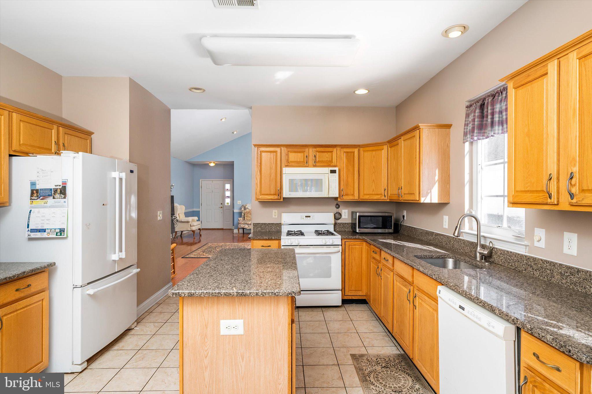 14 Hummingbird Drive Hamilton, NJ 08690 - Photo 7 of 24 a white kitchen with stainless steel appliances granite countertop a sink a stove and a refrigerator
