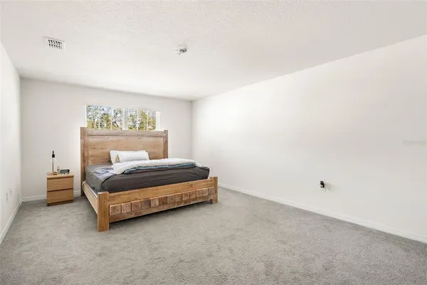 a bedroom with a bed and a large mirror
