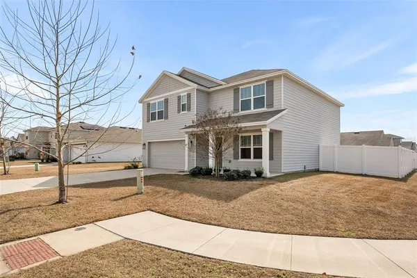 a view of a house with a yard and large tree
