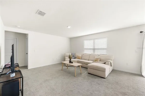 a living room with furniture a window and a flat screen tv